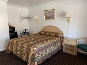une chambre d'hôtel avec un lit, une table et une chaise dans l'établissement Lark Motel Willits, à Willits