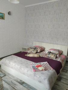 a bedroom with a bed with a purple comforter and pillows at Mini Hotel na Leningradke in Kyiv
