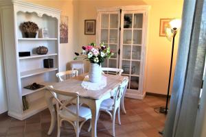 - une table à manger avec un vase de fleurs dans l'établissement CASA VACANZE CLAUDIA- 10 min da Siena, à Malignano