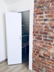 a room with a brick wall and a white door at Apartament Gdańsk Szklana Huta in Gdańsk