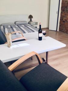 a white table with a bottle of wine and two chairs at Apartament Gdańsk Szklana Huta in Gdańsk