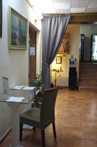 een kamer met een tafel, een stoel en een gordijn bij Hostal Europa in Barcelona