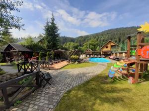a resort yard with a pool and a house at Villa Provans in Tatariv