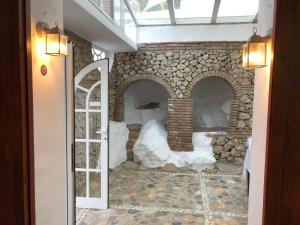 Habitación con chimenea de piedra y puerta de cristal. en La Casa Turquesa-Original, en Frigiliana