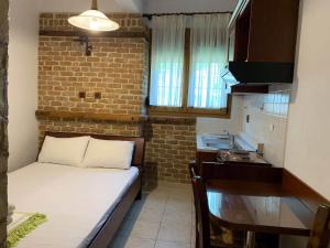 um pequeno quarto com uma cama e uma cozinha em Alexandros em Kato Loutraki