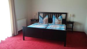 Schlafzimmer mit einem Bett mit blauen und weißen Kissen in der Unterkunft Maxl in Maltschach