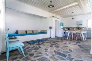 a living room with a blue couch and a kitchen at Myrto Holiday House in Stafylos