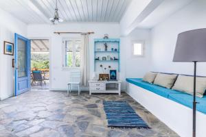 a living room with a blue couch and a table at Myrto Holiday House in Stafylos