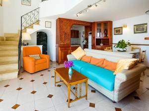 een woonkamer met een blauwe bank en een oranje stoel bij Belvilla by OYO Arienzo in Positano