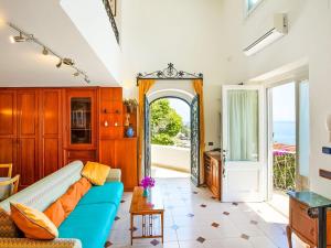 een woonkamer met een blauwe bank en uitzicht op de oceaan bij Belvilla by OYO Arienzo in Positano