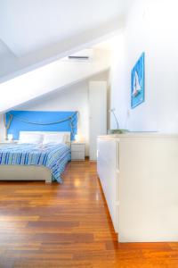 ein Schlafzimmer mit einem blauen Bett und einer weißen Kommode in der Unterkunft Il Nodo in La Spezia