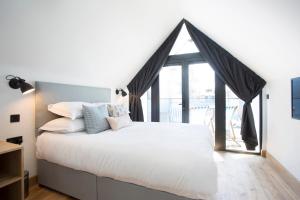 a bedroom with a bed and a large window at Warehouse Holiday Lets in Whitstable