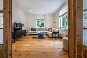 uma sala de estar com um sofá e uma televisão em Maison Chartreuse em Bruges