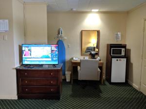 a room with a desk and a television on a dresser at Cheerio Inn - Glennville in Glennville