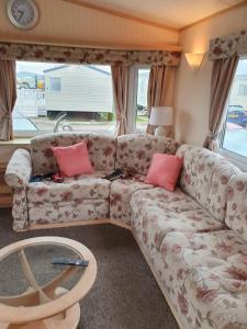 a living room with a couch with pink pillows at Goldensands in Foryd