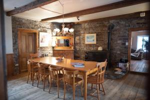 uma sala de jantar com uma mesa de madeira e cadeiras em Le Clos des Brumes em Chateau Richer