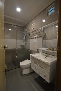 a bathroom with a toilet and a sink and a shower at Hemingway Cottage 海明威度假屋 in Semporna +37 photos