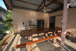 a large wooden table on a patio with a kitchen at Hemingway Cottage 海明威度假屋 in Semporna