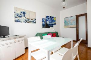 una sala da pranzo con tavolo e sedie bianchi di Easy Central Apartment - Milano Porta Romana a Milano