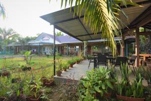 a restaurant with tables and chairs and plants at Hemingway Cottage 海明威度假屋 in Semporna
