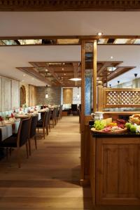 une salle à manger avec des tables, des chaises et de la nourriture dans l'établissement Hotel am Römerweg, à Fiss