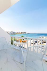 balkon ze stołem i krzesłami oraz plażą w obiekcie Nama Boutique Hotel w mieście Tinos +32 zdjęcia