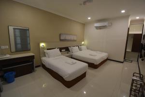 a hotel room with two beds and a sink at Hemingway Cottage 海明威度假屋 in Semporna