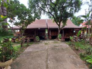 a house in the middle of a garden at Anouxa Riverview Guesthouse in Champasak