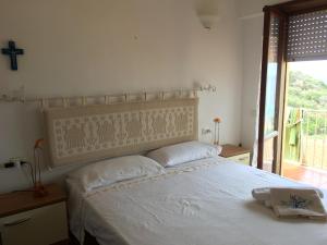 a bedroom with a white bed with a large headboard at Girasole sul mare, centre top sea view , dishwasher, air conditioning, wifi fibra ,free garage in Santa Teresa Gallura
