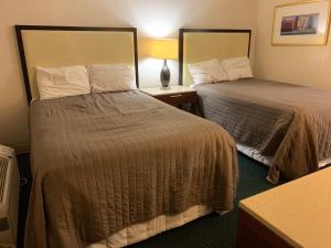 a hotel room with two beds next to each other at St. Mary’s Motel 