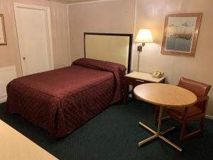 um quarto de hotel com uma cama e uma mesa em St. Mary’s Motel 