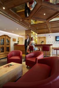 a man and a woman standing in a waiting room at Hotel am Römerweg in Fiss