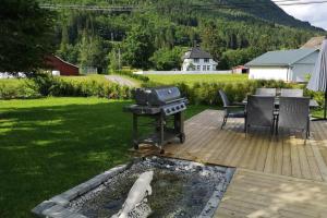 a grill on a deck in a yard with a table at Reinebu in Ørsta