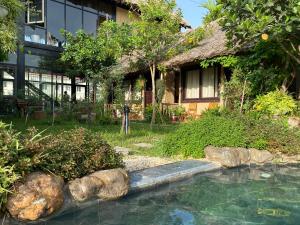 a house with a swimming pool in front of a building at May Homestay - Tam Coc Local Village in Ninh Binh