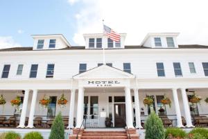 The Sacajawea Hotel في Three Forks: فندق ابيض مع العلم الامريكي على الواجهه