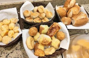 a group of baskets filled with different types of bread at Nico Palace Hotel in Guanambi