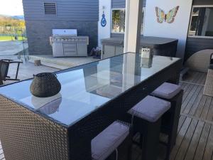 a glass table and chairs on a patio at Wilsons Retreat - Hosts On-site in Eskdale