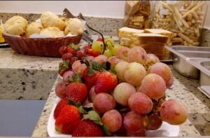 a plate of grapes and strawberries on a counter at Nico Palace Hotel in Guanambi +8 photos