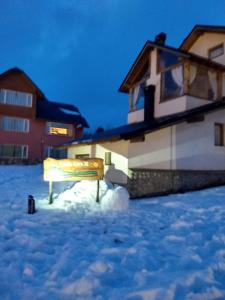 un banco sentado en la nieve frente a una casa en Villa Cerro Catedral en San Carlos de Bariloche