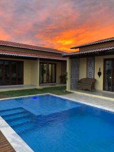 托魯斯的住宿－Chalés Polinésia，房子前面的蓝色游泳池
