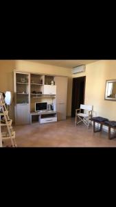Marina Apartments في مارينا دي غروسيتو: غرفة معيشة مع مطبخ مع ثلاجة وطاولة