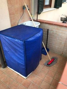 ein blauer Regenschirm und ein Mopp auf einem Fliesenboden in der Unterkunft Marina Apartments in Marina di Grosseto
