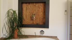 a bathroom sink with a mirror and a plant at viaDolceVita - Grüne Gästewohnung in Lana