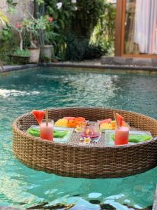 a picnic table in the water in a swimming pool at Naja Private Villa in Ubud