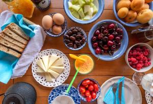 uma mesa de madeira coberta com taças de frutas e sobremesas em Papaevangelou Hotel em Papingo