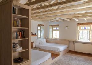a bedroom with two beds and a book shelf at Papaevangelou Hotel in Papingo