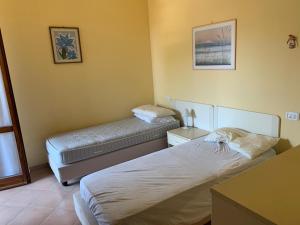 sypialnia z 2 łóżkami w pokoju w obiekcie Casa al mare w mieście Marina di Grosseto