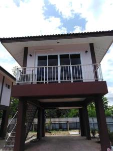 a house with a balcony on top of it at Lampang Ngeng Na Home in Lampang