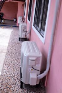 a row of gas meters on a pink wall at Villa Prescilla in Dumaguete