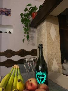 a bottle of wine sitting on a table with bananas and glasses at Taverna coctel in Poreč
